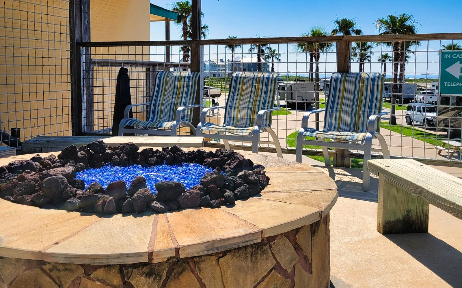 A circular fire pit surrounded by chairs on the resort's outdoor deck