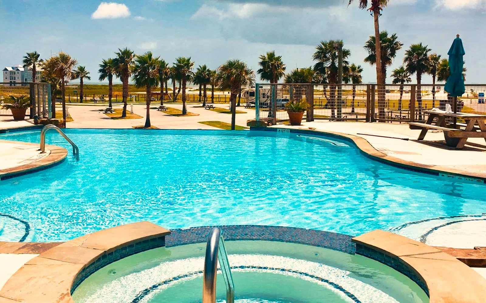 Sandpiper infinity pool and hot tub with palms and the Gulf beyond