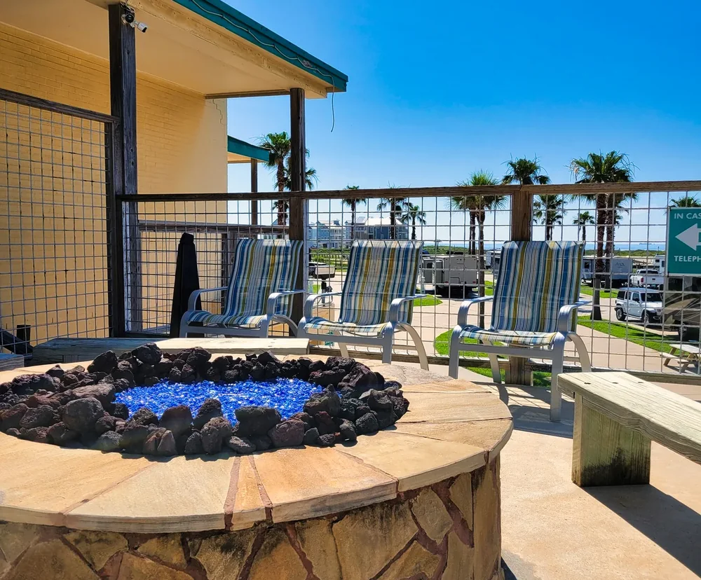 Lounge chairs around the fire pit with blue fire glass