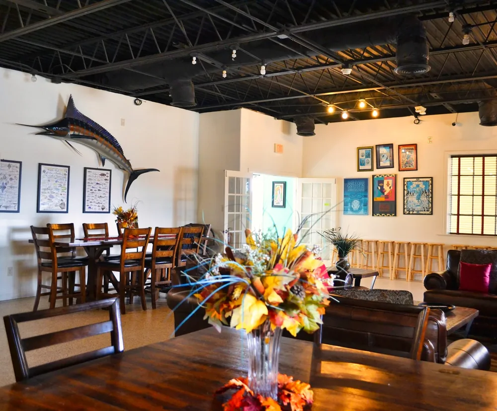 The social room, with long tables, string lights and a mounted marlin