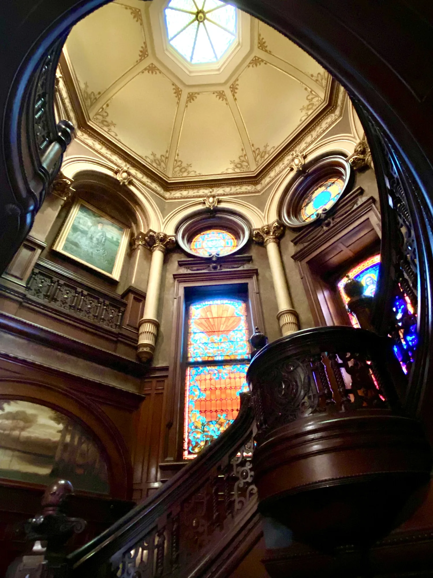 Looking up the rotunda staircase to stained glass and the dome