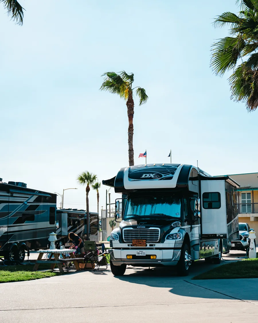Motorhome parked beneath palms at Sandpiper RV Resort