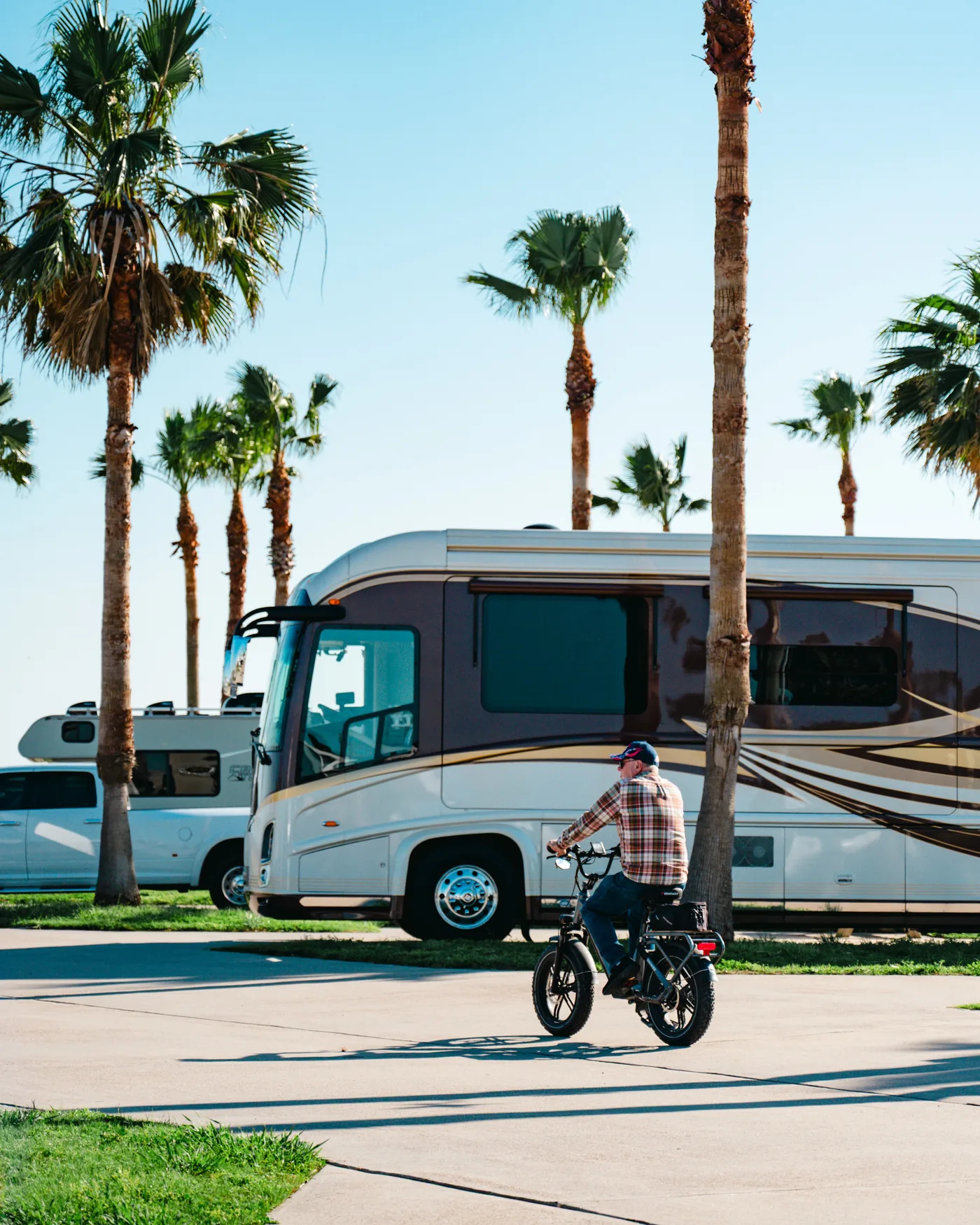 A cyclist riding beside a motorhome at the resort