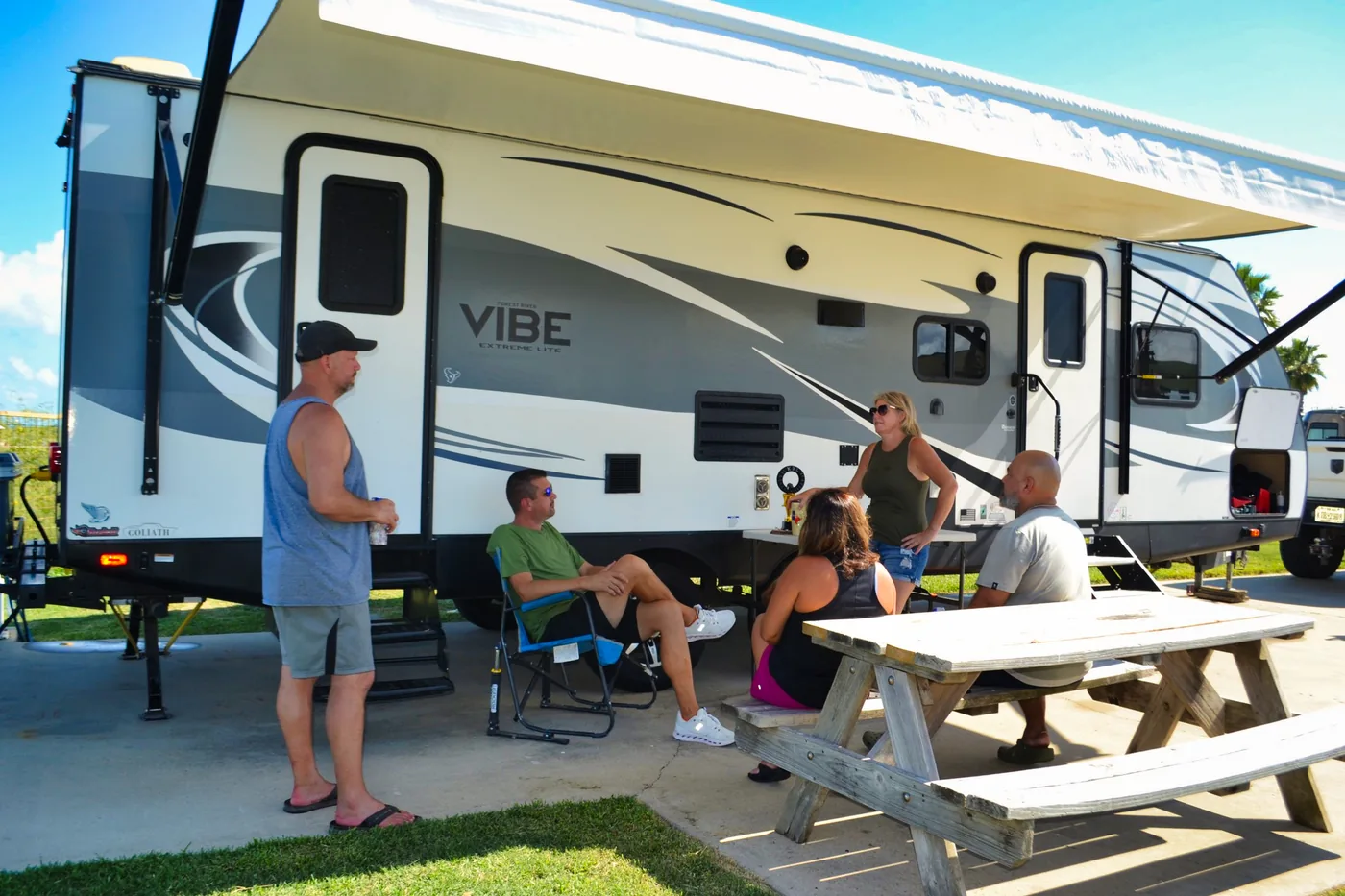 Guests gathered around a picnic table beside their RV